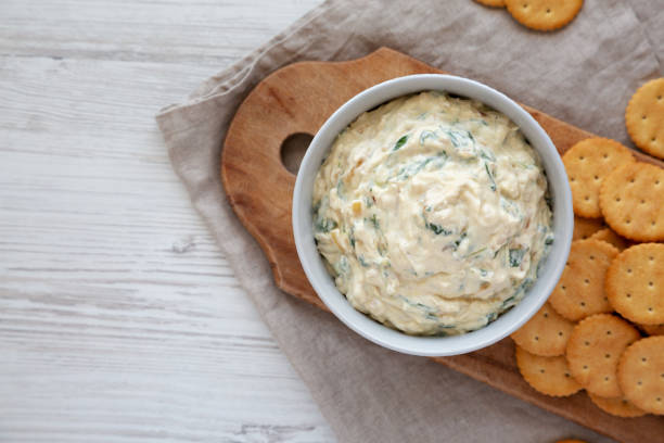 istock Homemade Caramelized Onion and Spinach Dip with Salty Round Crackers, top view. Flat lay, overhead, from above. Copy space. 1910046349