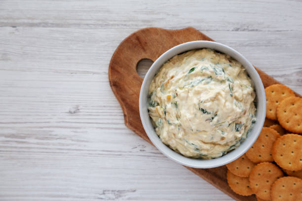 istock Homemade Caramelized Onion and Spinach Dip with Salty Round Crackers, top view. Flat lay, overhead, from above. Copy space. 1910046359