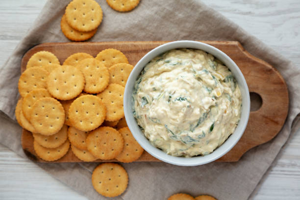 istock Homemade Caramelized Onion and Spinach Dip with Salty Round Crackers, top view. Flat lay, overhead, from above. 1910046889