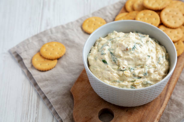 istock Homemade Caramelized Onion and Spinach Dip with Salty Round Crackers, side view. 1910046916