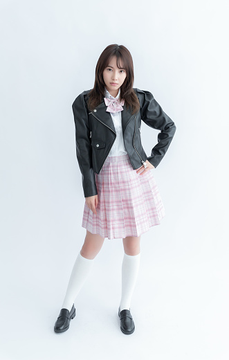 A Japanese school girl with a black leather jacket and pink plaid skirt