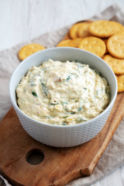 istock Homemade Caramelized Onion and Spinach Dip with Salty Round Crackers, side view. 1910047431