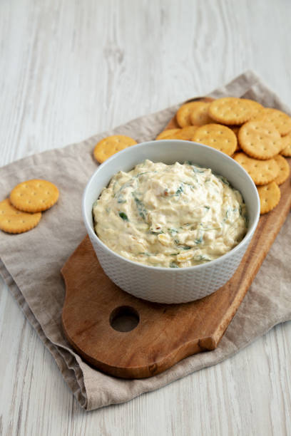 istock Homemade Caramelized Onion and Spinach Dip with Salty Round Crackers, side view. 1910047444