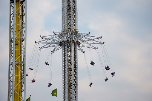 Munich, Germany - September 21, 2019: Young and old people enjoy the high tower ride at the Oktoberfest in Munich (Germany). The Oktoberfest is the biggest beer festival of the world with over 6 million visitors each year.