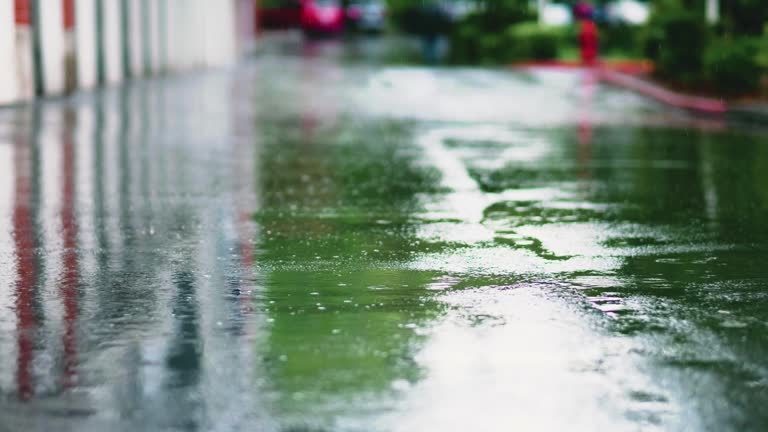 Establishing shot of rain falling on pavement. stock video