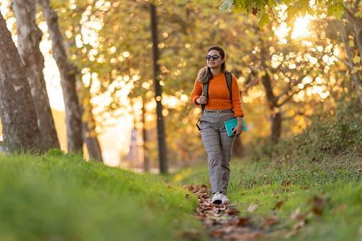 Mature student woman walking in forest in autumn