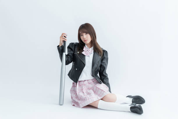 istock Asian school girl holding a baseball bat 1910116599