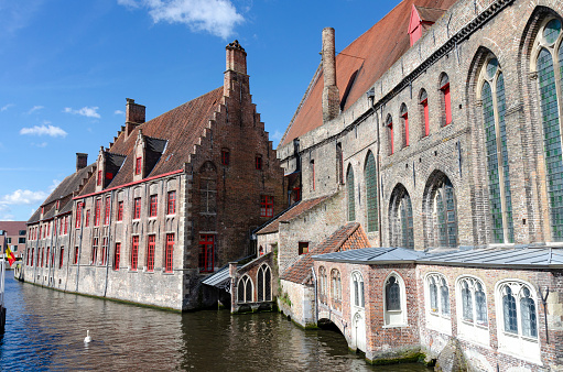 The Rozenhoedkaai canal, historical brick houses and the Belfry in Bruges medieval Old Town, Belgium, a UNESCO World Culture Heritage site
