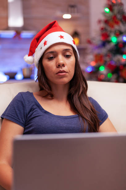 istock Girl reading business email on laptop computer working during christmastime 1910122831