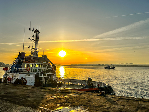 Sunrise with tug boat in foreground