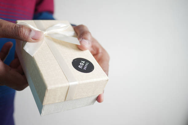 istock hand putting a thank you sticker on a gift box 1910154914
