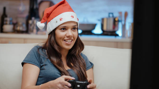 istock Person with santa hat winning video games with joystick 1910164884