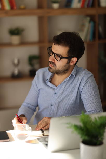 istock Serious male employee busy using modern laptop in office 1910173319