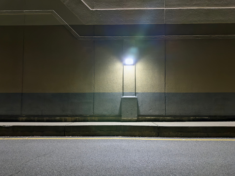 Detail of a blank illuminated wall of a concrete building at nighttime