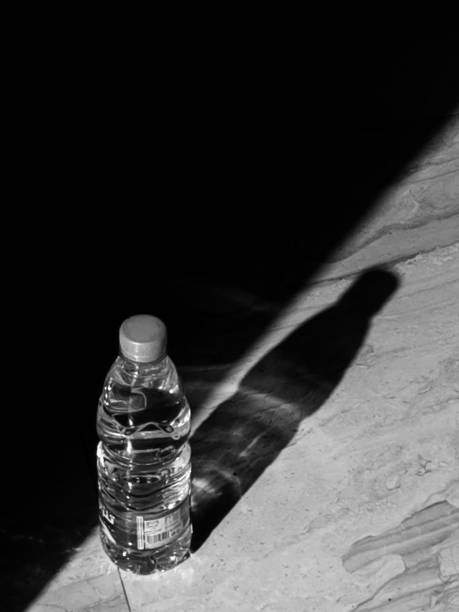 istock water bottle on the tile floor. black & White photo 1910187366