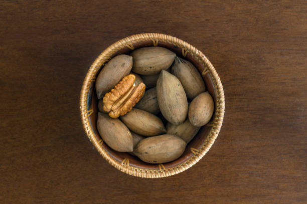 Selective focus on peeled pecan nut among shelled Pecan nuts in a  bowl