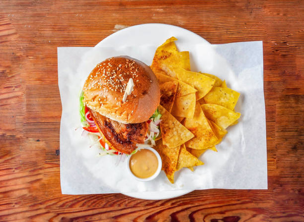 istock Pig burger with cucumber, tomato and cabbage, mayonnaise dip and crackers served in dish isolated on wooden table top view of hong kong food 1910204330