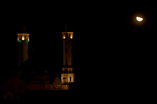 Half moon with the ground in front of the spire of the mosque