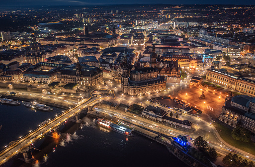 Aerial view of Dresden at dawn. Illuminated Katholische Hofkirche, Frauenkirche, Zwinger, Elbe river and Semper Opera House. Germany - Saxony