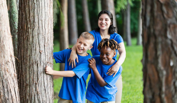 istock Two boys with camp counselor in park at summer camp 1910259980