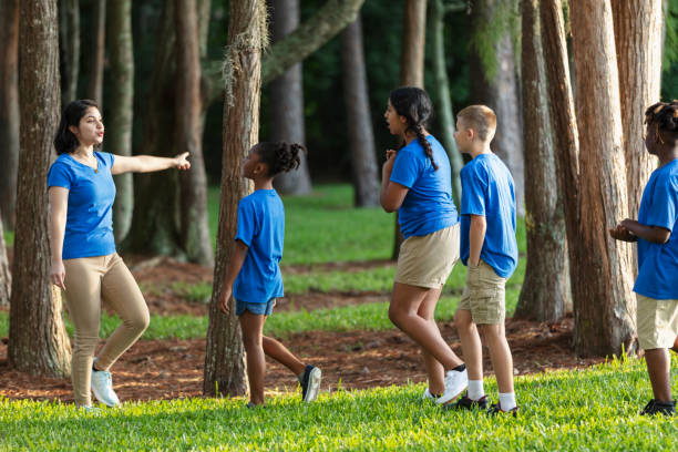 istock Children in summer camp at park walking with counselor 1910260521