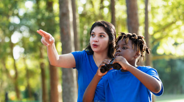 istock Boy with binoculars and summer camp counselor 1910260538