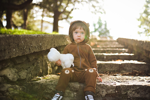 Portrait of a cute toddler girl with toy in nature.