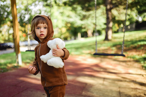 Portrait of a cute little girl holding a stuffed toy.