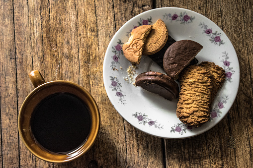 breakfast, cookies with coffee served on a rustic wooden table, overhead photo