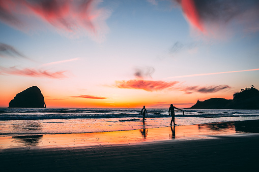 Two surfers coming in from a sunset session.