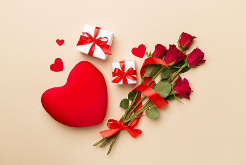 Valentines day gifts with red roses on color background, top view