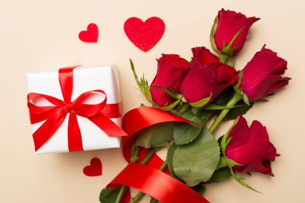 istock Valentines day gift box with red roses on color background, top view 1910280229