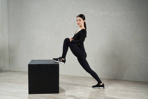 istock Fit girl posing, while stretching leg, exercise in fitness studio. 1910306910