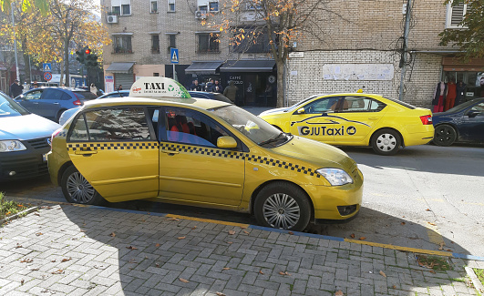 Tirana, Albania - December 20, 2023: Taxi Stand, Parking Lot, Retail Store, Building Exterior, People Scene