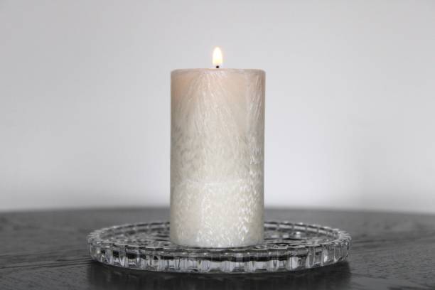 istock Small White Candle Pillar on a Crystal Plate Holder. 1910333313