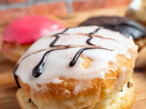 Sweet donut on a wooden background. Sweet bun close-up.