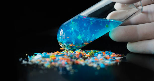 Concept of water pollution and industrial waste management. Macro shot of a test tube full of micro plastics collected from the beach. microplastic stock pictures, royalty-free photos & images