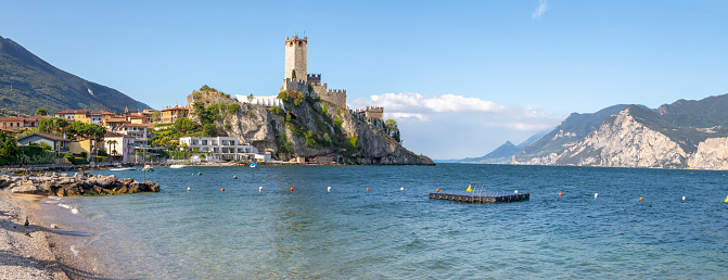Malcesine - The beach of Lago di Garda lake with the town and castle in the background.