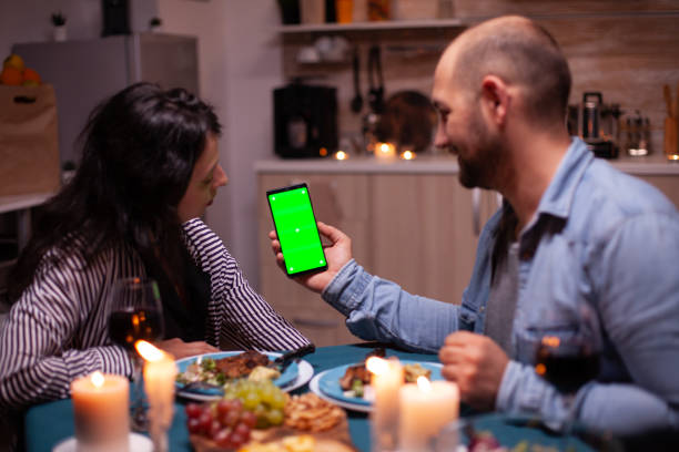 istock Couple watching phone with green screen 1910453499