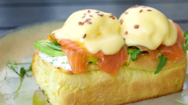 Traditional egg benedict with slices of bacon on toast, poached egg and hollandaise