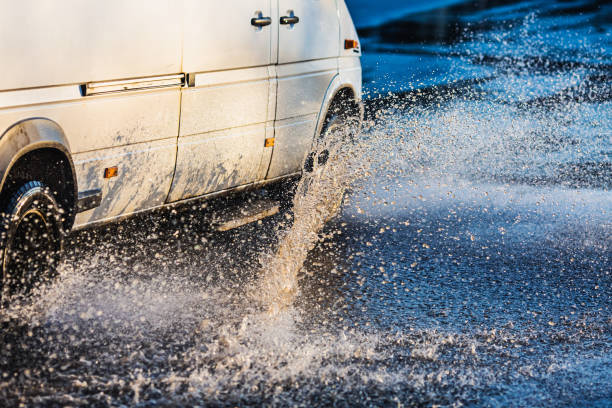 car wheel in puddle. torrential rain. - skidding car tire rain stock-fotos und bilder