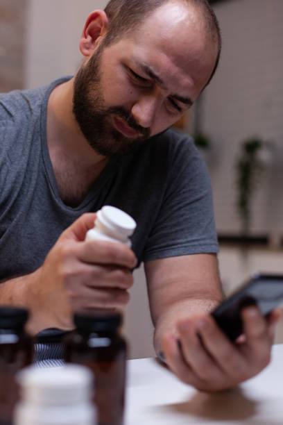 istock Caucasian man with headache looking at smartphone 1910488014