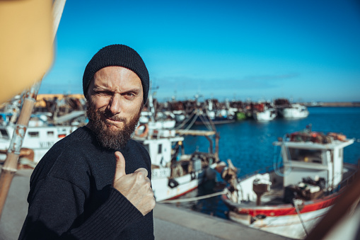 Fisherman portrait at harbor: fishing industry in Italy, in the Mediterranean Sea