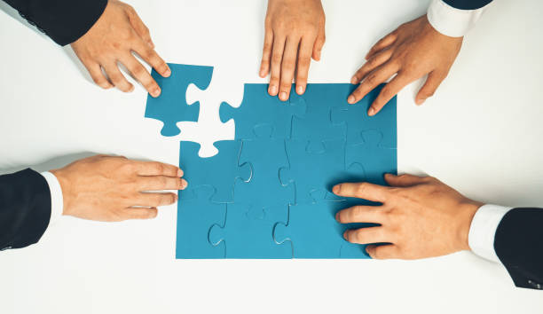 istock Top view panorama banner of business team assembling jigsaw puzzle. Shrewd 1910504318