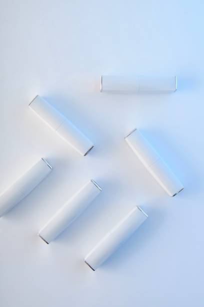 Cosmetics. Texture. Lots of white lipsticks on light background.