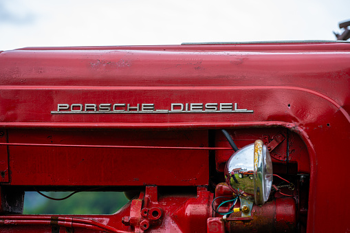Lyngdal, Norway - June 27 2023: Red vintage Porsche Diesel tractor in a field.
