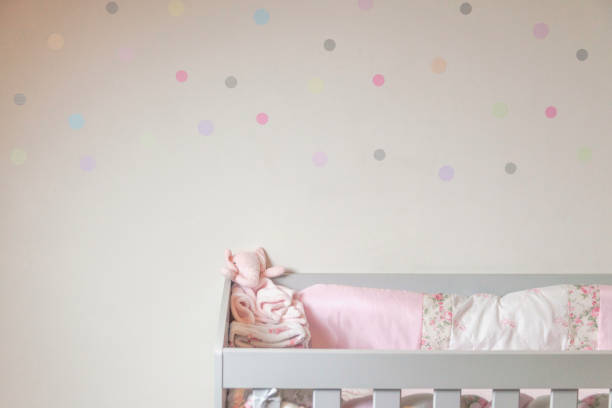 istock Baby crib with colorful polka dot wal 1910614213