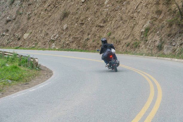 istock A motorcycle passing a curve on a mountain road. The driver wears a helmet 1910646966
