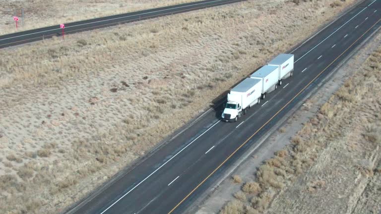 Drone Shot of a White Semi Truck with Three Trailers Drving West on I-70 in Utah on a Winter Afternoon