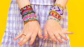 Beaded bracelets on the hands of a little girl. Multicolored jewelry on his hands. Beading for children.